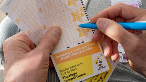 Man filling out EuroMillions lottery ticket