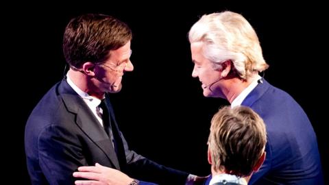 Dutch Prime Minister Mark Rutte (L) of the Liberal Party (VVD) and the right-wing Freedom Party (PVV) leader Geert Wilders (R) shake hands during a TV debate