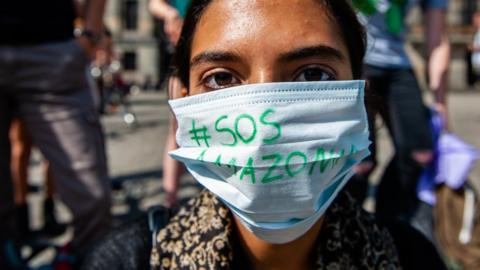 A protester wears mask with #SOSAmazonia on it