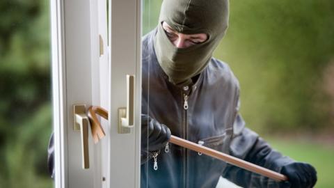 Burglar breaking into house