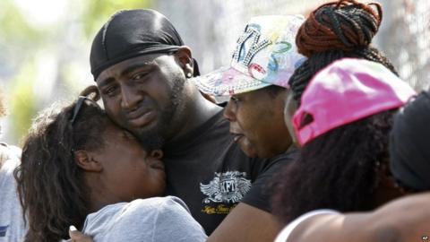 Veronica Trammell, left, is embraced outside a home where an early morning fire killed multiple people