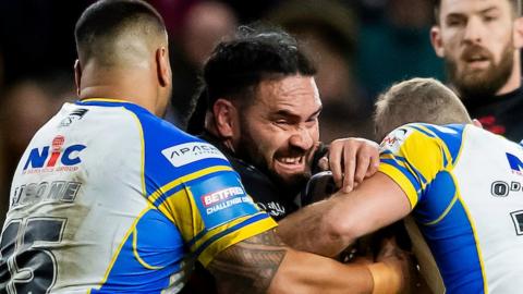 St Helens' Leeds old boy Konrad Hurrell is tackled by Rhinos pair Sam Lisone and Jarrod O'Connor