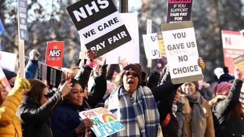 NHS nurses hold placards during a strike
