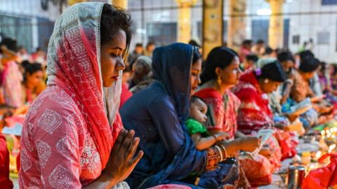 Hindu devotees sit together in a temple in Dhaka, Bangladesh