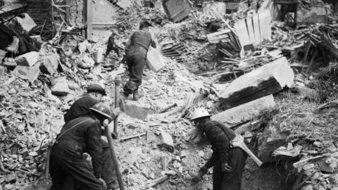 Rescue workers search through the rubble of Eglington Street in Belfast, Northern Ireland after a German Luftwaffe air raid, 7 May 1941.