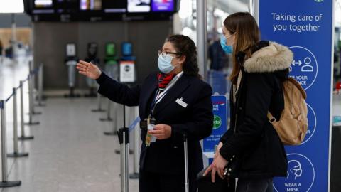 An airline employee helping someone at Heathrow Airport