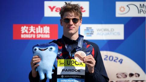 Hector Pardoe shows off his bronze medal on the podium