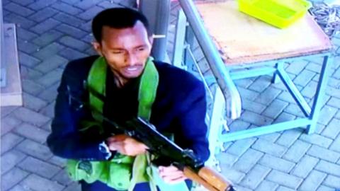 A gunman is pictured as he and others make their way into a hotel and office complex in Nairobi, Kenya, 15 January 2019