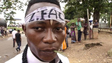 Kamuina member - Militia member standing in Kananga town.