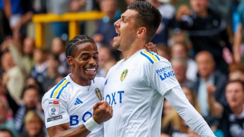 Leeds forwards Crysencio Summerville and Joel Piroe celebrate the latter's goal against Millwall at The Den