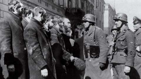 Nazi soldiers question Jews in Warsaw in 1943.