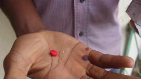 A man holds a Tramadol pill