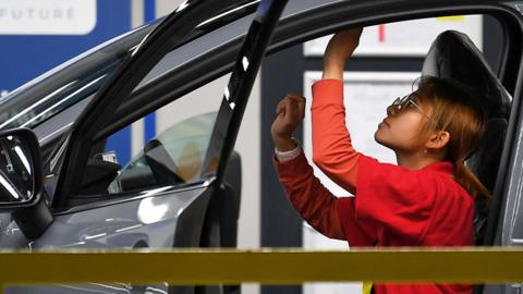 A female worker checks a car on the production line at the Nissan factory in Sunderland
