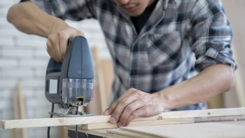 A man sawing timber