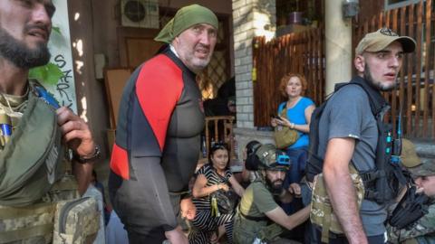 Rescuers react to Russian shelling during evacuation efforts of those trapped by flooding in Kherson region