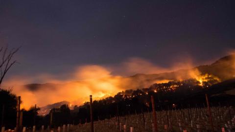 Fire glows on a hillside in Napa, California on October 9, 2017, as multiple wind-driven fires continue to whip through the region.