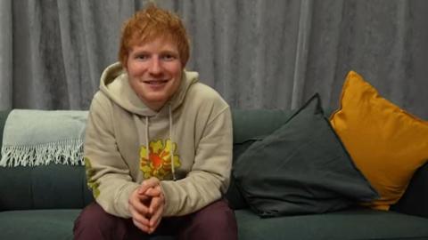 Ed Sheeran sitting on a sofa