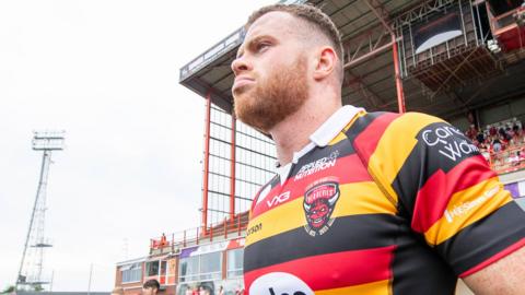 Joe Burgess stands in front of the west stand at Hull KR - where he now be cheered rather than jeered