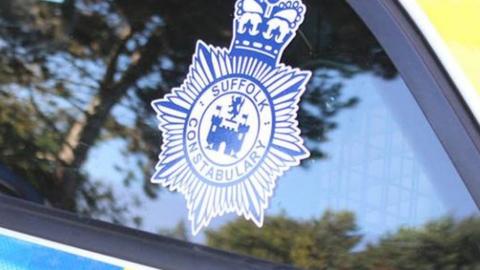 Suffolk Police logo on a police car.