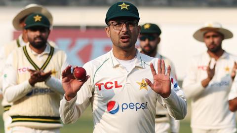 Pakistan spinner Abrar Ahmed holds up the ball as he walks off after taking seven wickets on debut