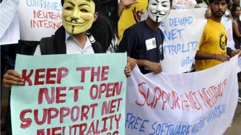 Indian activists wear masks as they hold placards during a demonstration supporting 'net neutrality' in Bangalore