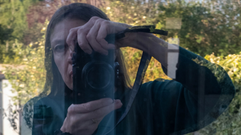 Karren Visser taking a photo, shown in reflection