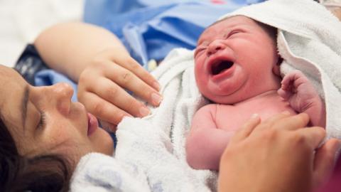 Mum holding newborn baby in hospital