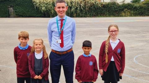 Headteacher and pupils in a school