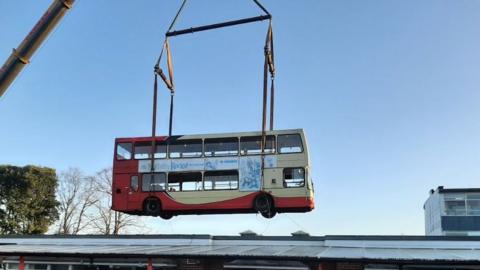 A bus library hanging from a crane