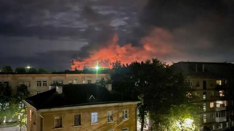 A handout photo made available by the Governor of Russian Pskov region Mikhail Vedernikov Telegram channel shows smoke billowing and explosions light after Russian militaries destroyed drones in Psko