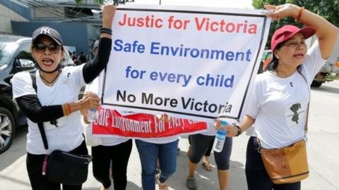 Protesters hold signs during a march demanding justice for a child rape case, in Yangon