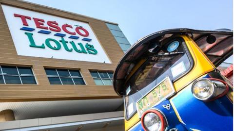 A Thailand's traditional Tuk Tuk waits for customers outside a Tesco-Lotus supermarket in Bangkok.