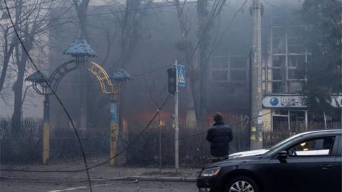 A person looks at a building after a blast, amid Russia's invasion of Ukraine, in Kyiv