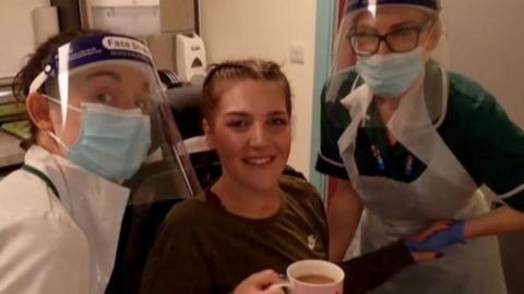 Hospital staff with patient holding cup of tea