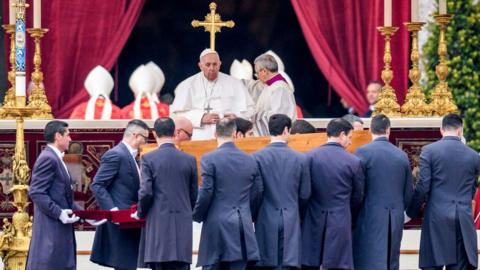 Pope Francis attends the funeral mass for Pope Emeritus Benedict XVI as pallbearers carry the coffin at the end of the funeral mass at St. Peter's square on January 5, 2023