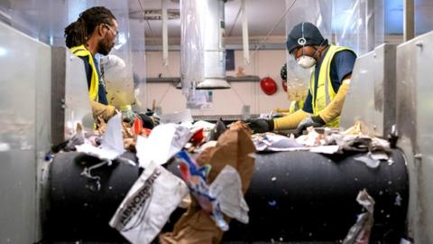 Photo of two people sorting recycling