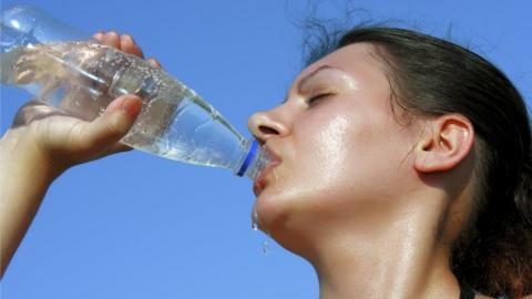 Woman drinking water in the sunshine
