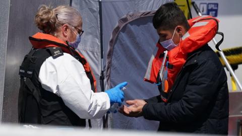 Border Force officer with migrant on board vessel at Dover on 5 August 2021