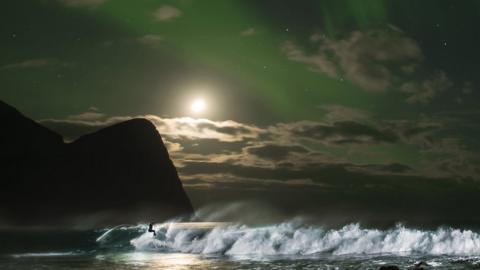 Fanning, 35, hit the surf as the Aurora Borealis lit up the archipelago of Lofoten.
