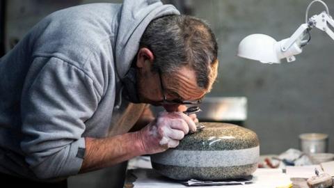 Production supervisor John Brown hand-finishes a stone in the workshop