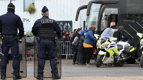 Migrants line up during the evacuation by police forces of a camp occupied by homeless migrants in Grande-Synthe