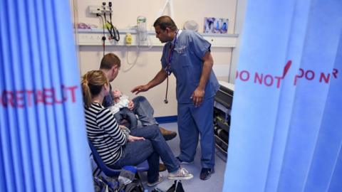 A doctor talking to a couple with their baby