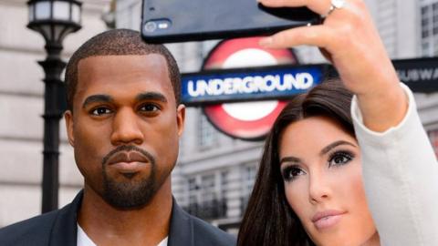 Kanye West's wax figurine alongside Kim Kardashian's during a museum promotion outside a London tube station