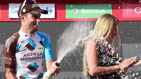 A hostess is caught in the Champagne spray at last year's La Vuelta