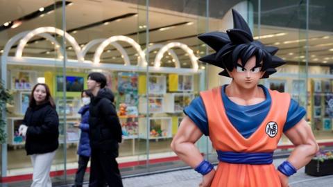 Passersby walk past a statue of Son Goku, a character of Dragon Ball created by a Japanese manga artist Akira Toriyama, in front of Bandai Co. in Tokyo, Japan, 08 March 2024.