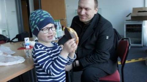 Andreas Graff smiles as he watches his son Julius play with a banana.