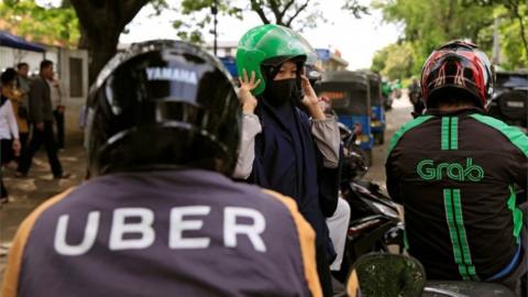Grab and Uber motorbike riders side by side