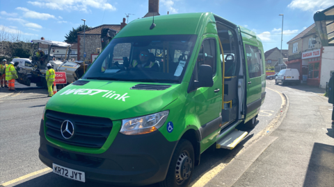 A green WESTlink minibus parked on a road