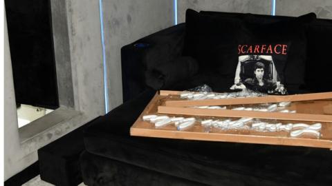 A cinema room with a Scarface cushion