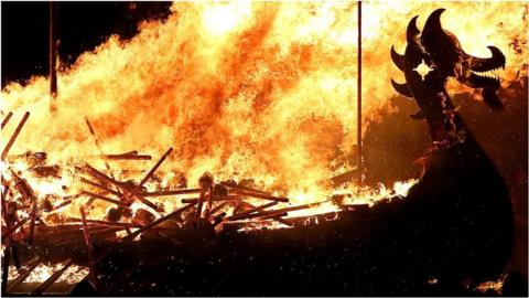 A burning boat with a dragon's head